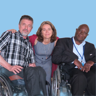 Jean-Luc Simon & Joshua are sitting in their wheelchair with Yutta Fricke behind them with her arms linked.